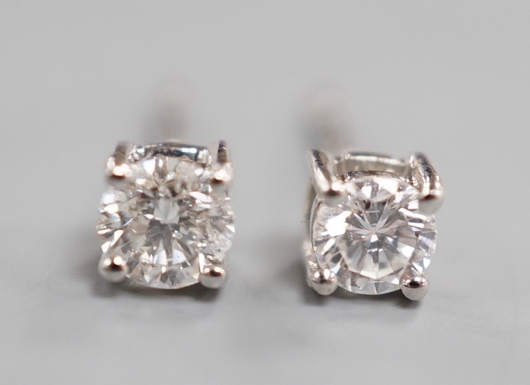 A modern pair of 9ct white gold and solitaire diamond set ear studs, gross 0.8 grams